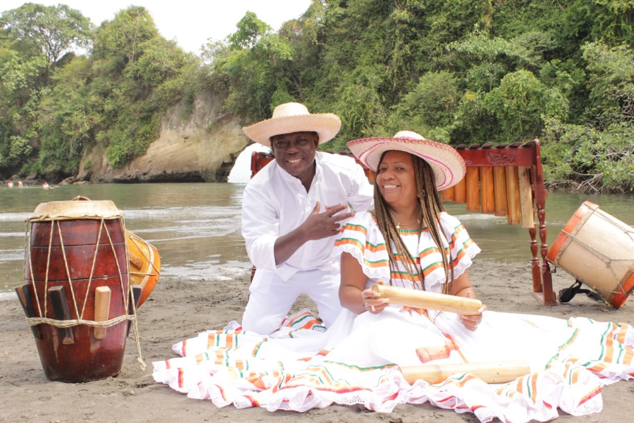 Integrantes de Sonidos Profundos sentados junto a la marimba y el bombo a orillas del río