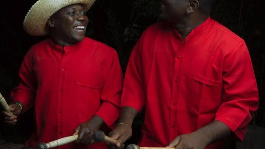 Dos percusionistas de Sonidos Profundos interpretando bombo con camisa roja